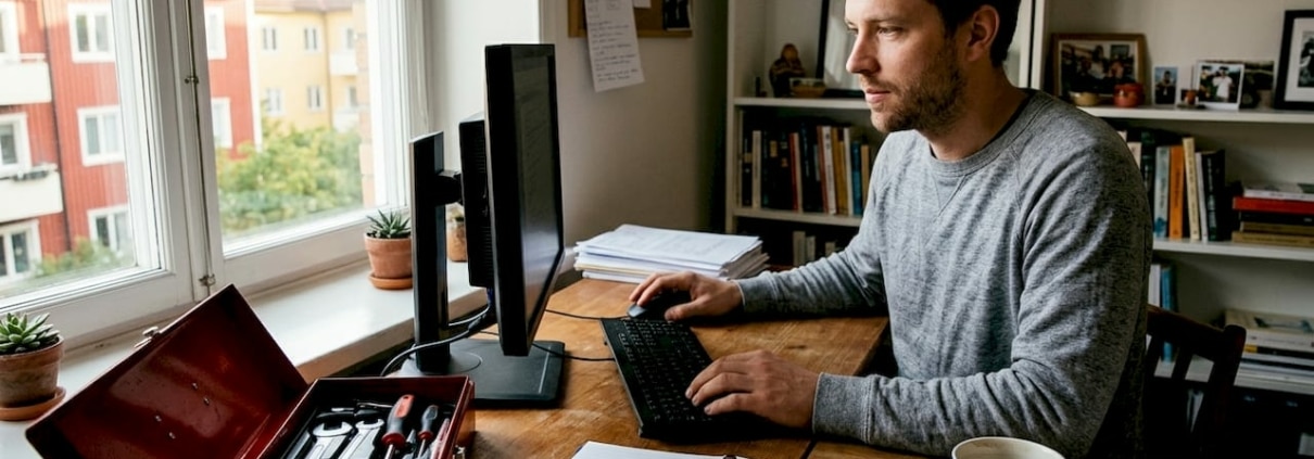 En person sitter hemma och försöker få ordning på sin strulande dator.