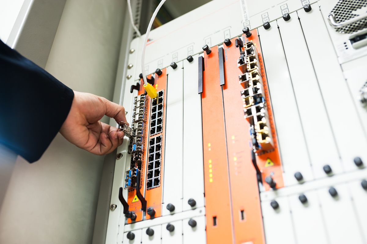 Tekniker monterar utrustning i serverskåp