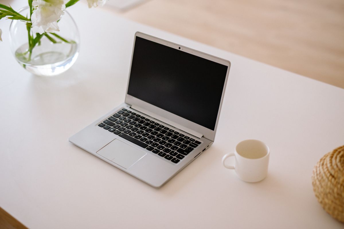 Laptop på ljust skrivbord i hemmiljö