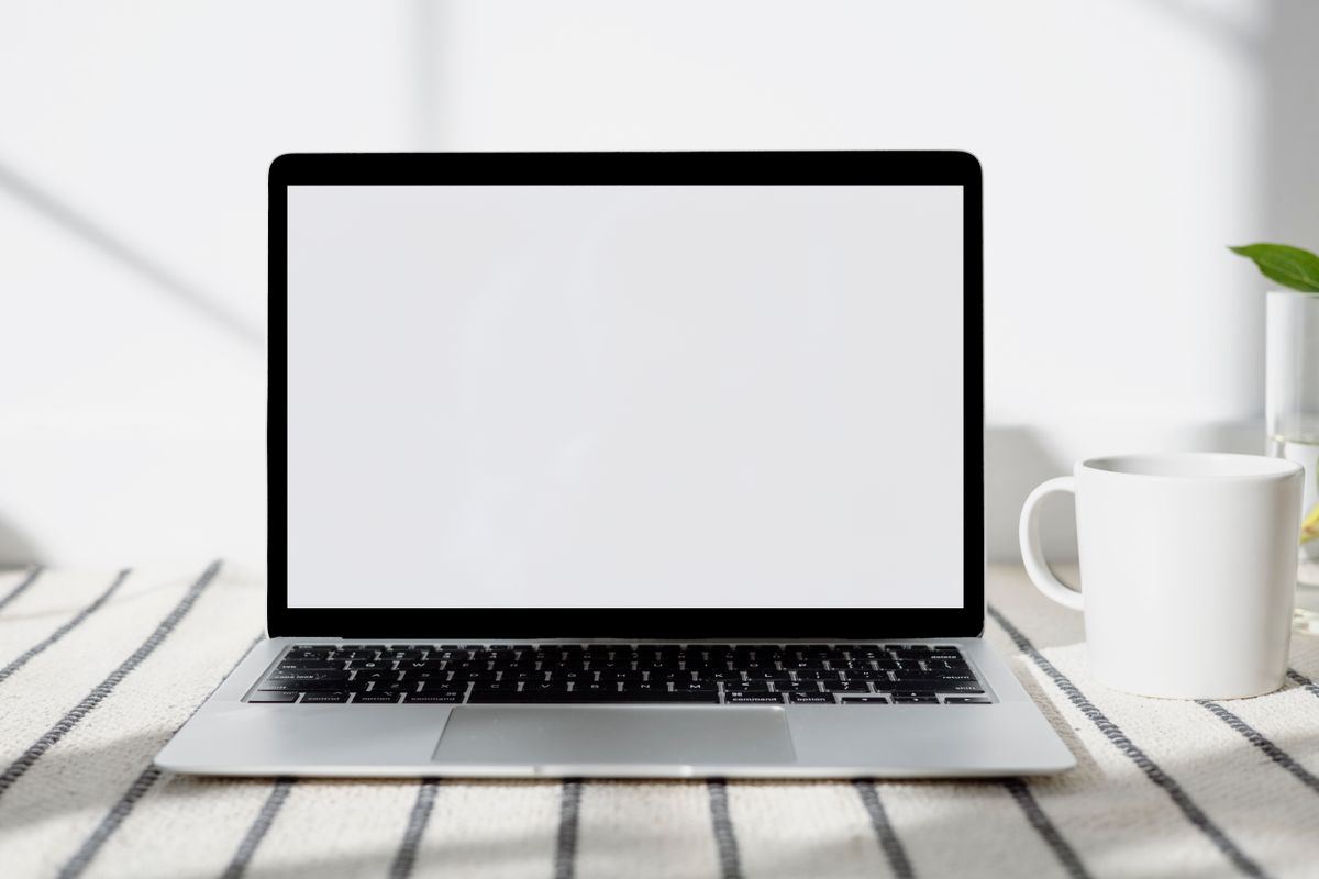 Laptop på ljust skrivbord i hemmiljö