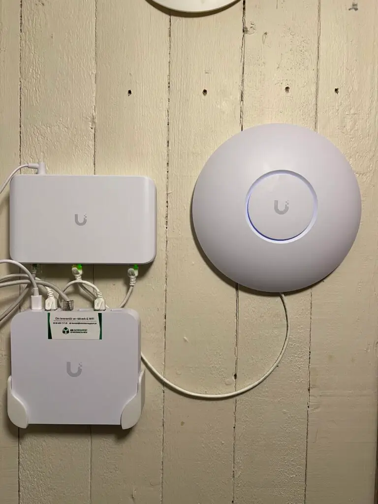 UniFi-gateway, switch och accesspunkt monterade på en panelvägg i en villa i Saltsjö-Duvnäs