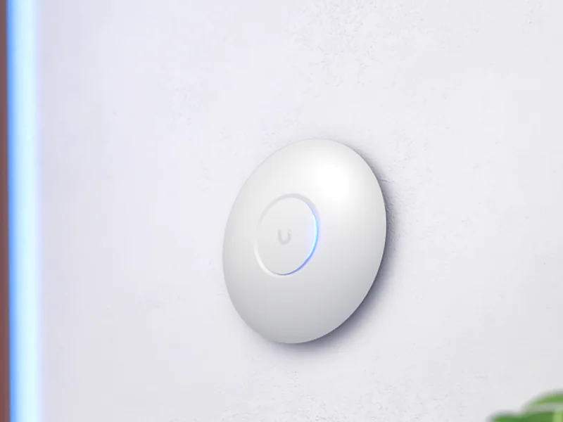 UniFi U7 Lite accesspunkt på en ljus vägg i hemmet
